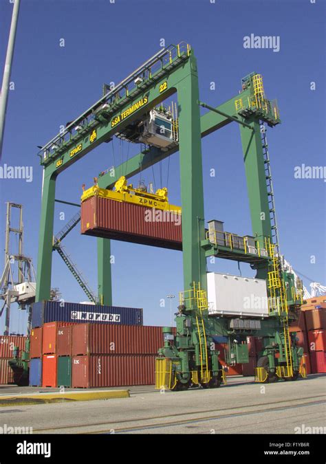 Shipping Container Being Handled By A Transtainer Crane At Port