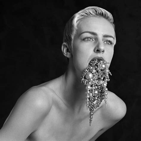 A Black And White Photo Of A Woman With Pearls On Her Face Eating