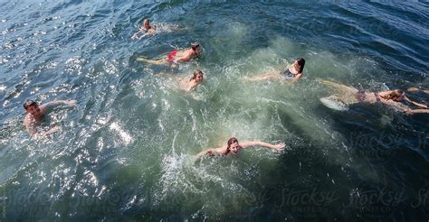 A Group Of Friends Laugh And Swim In The Ocean By Stocksy Contributor