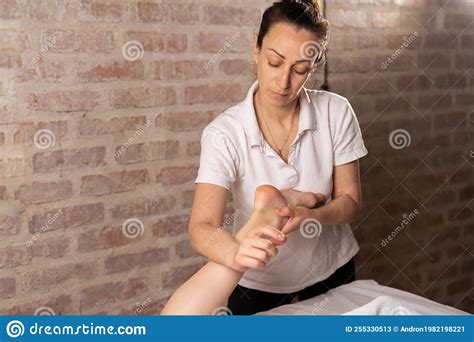 Doctor Masseur Making Manual Massage Of Feet For Lying Woman In Wellness Clinic Osteopath
