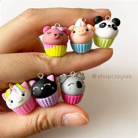 A Hand Is Holding Five Small Cupcakes With Animals On Them In Different