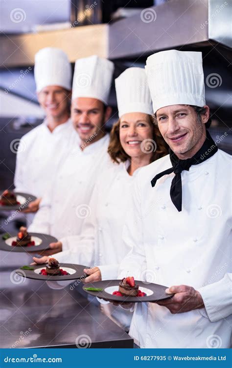 Portrait Of Happy Chefs Presenting Their Dessert Plates Stock Image