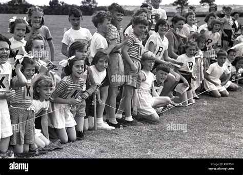 1950s Historical School Children In Sitting On A Grass Field Cheering