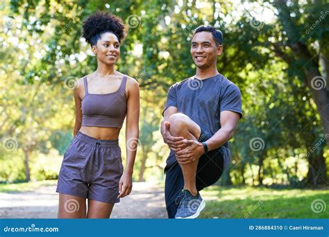 Beautiful Couple Stretch Legs Together Before Running In Park Fitness