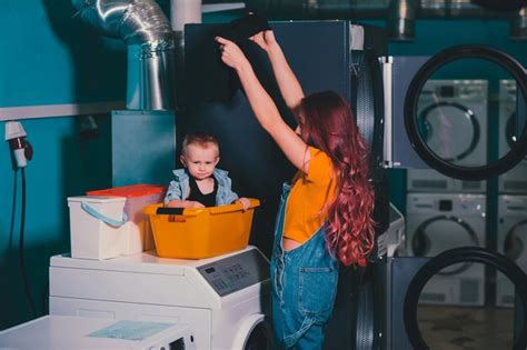 Premium Photo Young Woman Searching Clothes In Washing Machine Drum