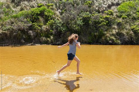 Girl Running Through A Freshwater Creek Del Colaborador De Stocksy Gillian Vann Stocksy