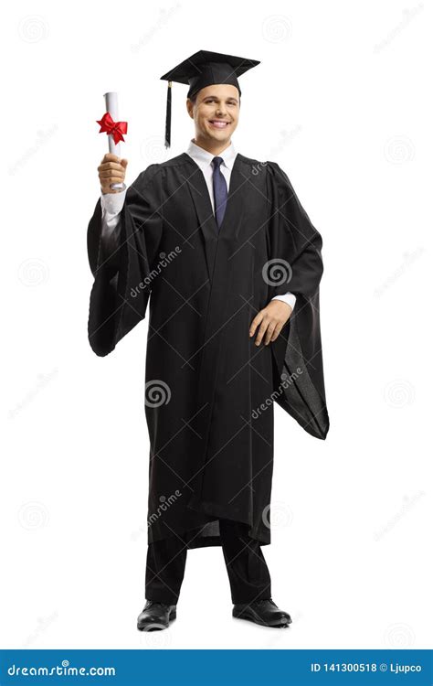 Young Man In A Black Graduation Gown And Cap Holding A Diploma Stock