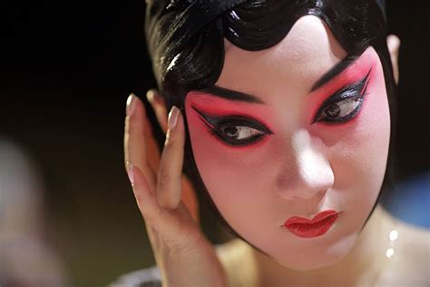 A Beijing Opera Actress Applies Makeup At The Back Stage Before The