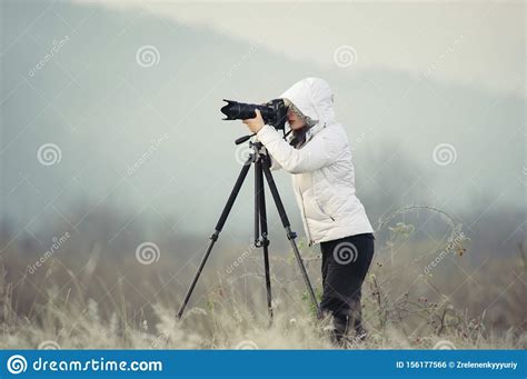 Photographer With Camera And Tripod Outdoor Taking Landscape Picture