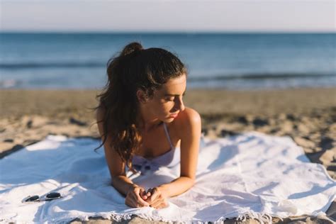 Chica Tomando El Sol En La Playa Foto Gratis