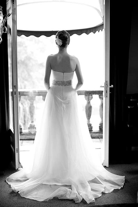 A Woman In A Wedding Dress Looking Out The Door
