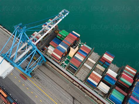 Crane Loading Shipping Containers To Cargo Boat Ship In The Port By
