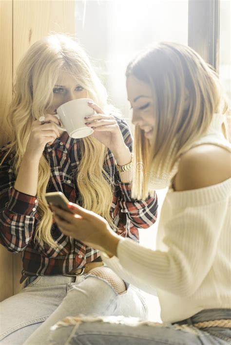 Twee Meisjes Die Pret Hebben Terwijl Het Drinken Van Koffie Stock Foto