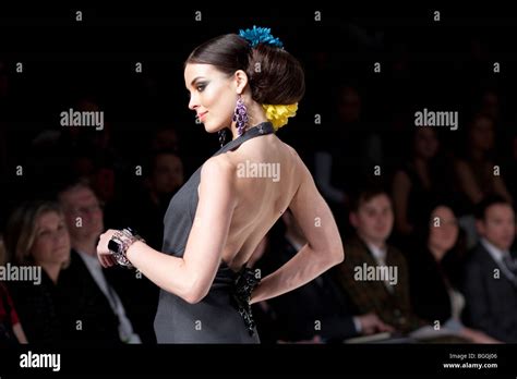 Back Of A Model At A Runway Fashion Show While Audience Are Looking In