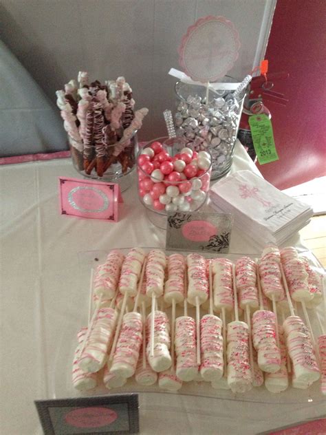 a table topped with lots of pink and white candies next to boxes of candy