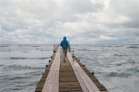 Man Walking On Pier On The Background Of Stormy Sea Stock Photo Image