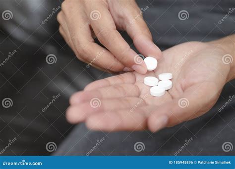 Close Up Of Woman Taking In Pill She Is Pours The Pills Out Of The