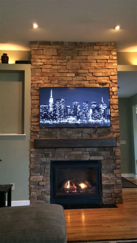 The stone going from floor to ceiling makes a nice big impact on the space without cluttering it up with extra ledges and vertical surfaces. Floor to ceiling stone fireplace, DIY, remodel ideas ...