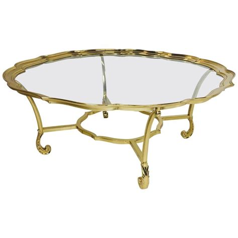 There are minor scuffs, scrapes and wear to the as found finish. Hollywood Regency Scalloped Edge Brass and Glass Coffee ...