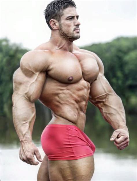 A Man In Red Trunks And No Shirt Is Posing For The Camera With His Hands On His Hips
