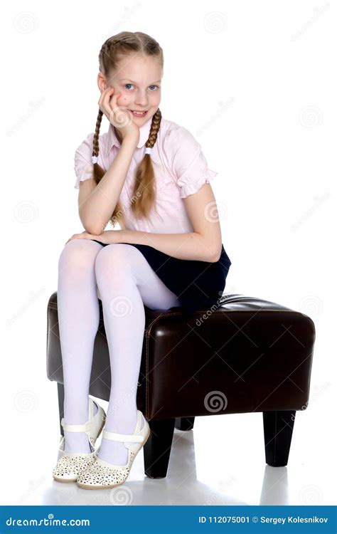 Girl Schoolgirl With Long Pigtails Sitting On The Couch Stock Image
