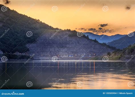 Golden Sunset Sky With Fluffy Clouds Over Reflective Silky Lake Stock