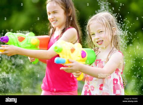 Adorable Little Girls Playing With Water Guns On Hot Summer Day Cute