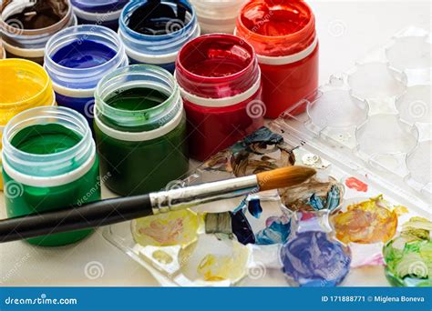 Paint Brushes And Watercolor Paints Tempera Paints On The Table In A