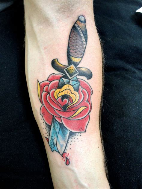 Dagger tattoos are often split in the middle to depict stabbing, and a dagger typically appears to be stabbed through the head of a creature, a flower, a heart, or even the subject's skin. rose with dagger | Dagger tattoo, Rose tattoos, Tattoos