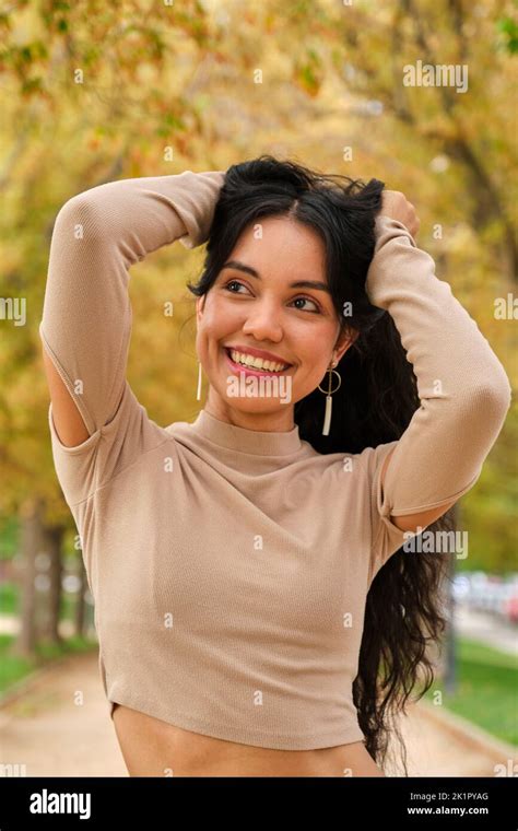 Young Latin Girl Holding Her Hair And Smiling Stock Photo Alamy