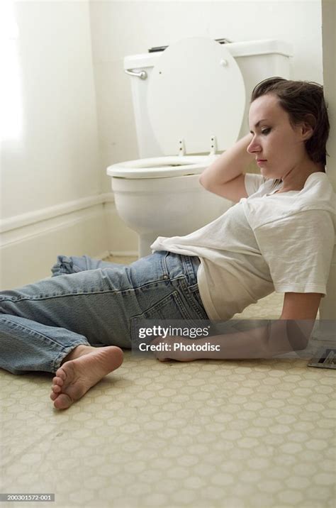 Sick Young Woman Sprawled Out On Bathroom Floor By Toilet High Res