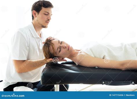 Young Physiotherapist Doing A Neck Treatment To The Patient In A