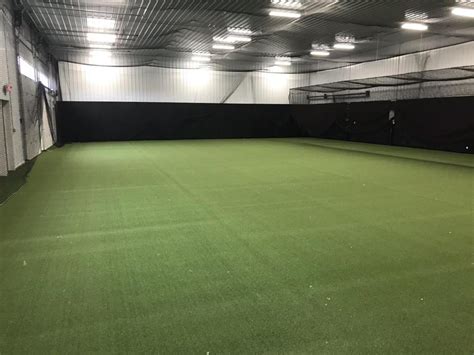 Fieldhouse arena artificial turf & custom shell netting installation. Twin Creeks Indoor Baseball Facility