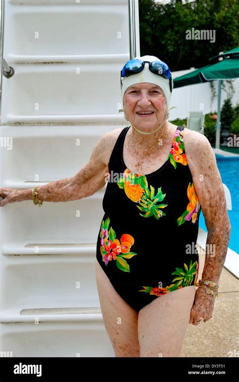 A Senior Citizen Woman In A Bathing Suit Swim Cap And Goggles Enjoys A