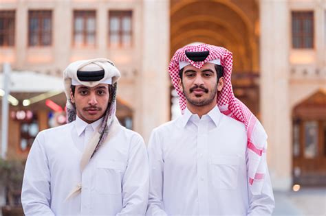 Two Young Men From Doha Pose Wearing Traditional White Clothing Called