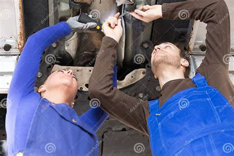 Two Mechanics Repairing A Car In Hydraulic Lift Stock Photo Image Of