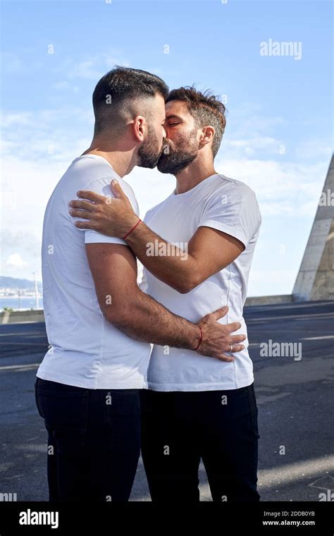 Una pareja gay cariñosa besando en el puente contra el cielo Fotografía de stock Alamy