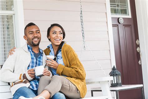 This activity is a staple of most urban areas in the united states, and helps contribute to a lively atmosphere, for those sitting and also those passing by. Young Mixed Race Couple Drinking Coffee On Porch Swing ...
