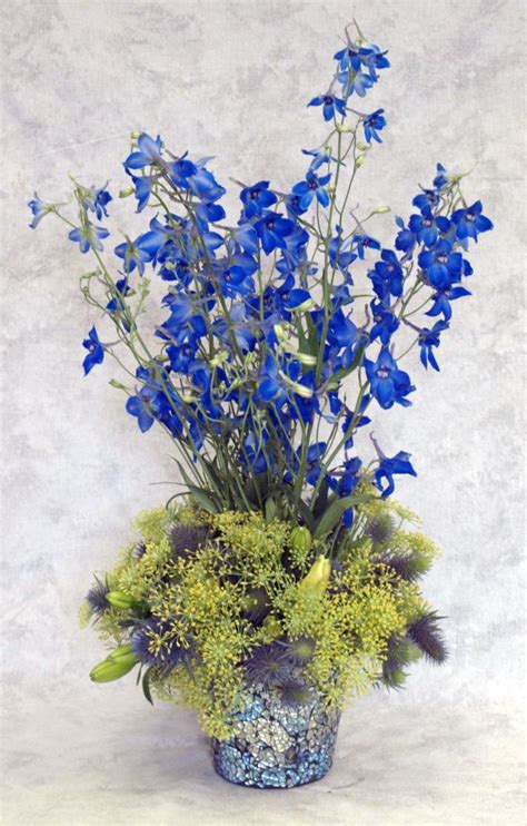 While most people plant succulents in pots or the ground, these gardening favorites make a lovely addition to a centerpiece, especially a green one! Blue and Green Tall Arrangement | Flower arrangements ...