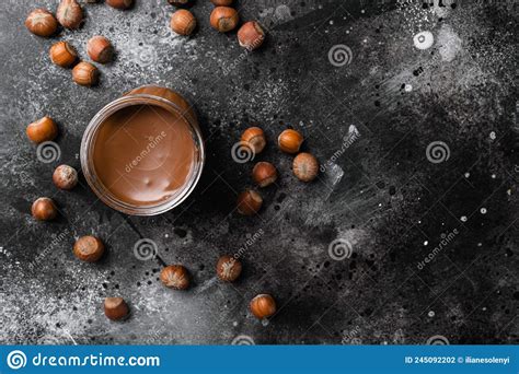 Chocolate Hazelnut In Jar With Nuts On Black Dark Stone Table
