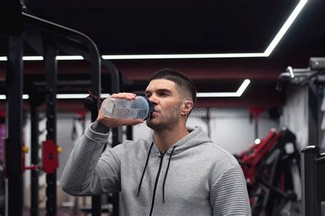 Muscular Men Drinks Protein Or Water Energy Drink In The Gym Stock