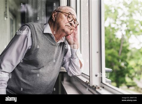 Portrait Of Sad Senior Man Looking Out Of Window Stock Photo Alamy