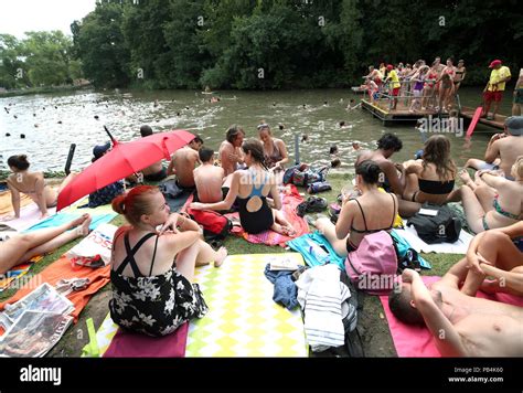 People Sunbathing At The Mixed Bathing Pond On Hampstead Heath London As Heatwave Conditions