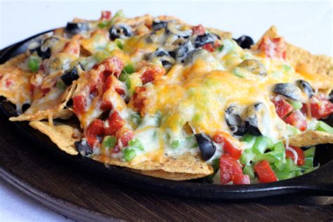 This recipe calls for the ingredients of a pizza arranged into a fun nacho plate. Pizza Nachos - Simple Comfort Food