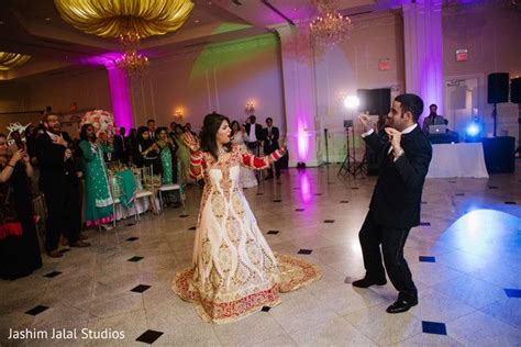 A Bride And Groom Dancing On The Dance Floor In Front Of An Audience At