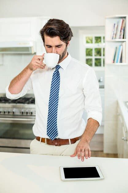Premium Photo Businessman Drinking Coffee While Using Digital Tablet