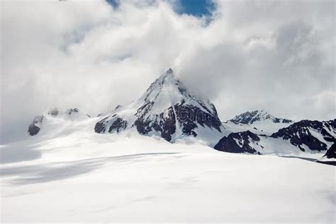 Snow Covered Mountain Peak Above The Clouds Stock Photo Image Of