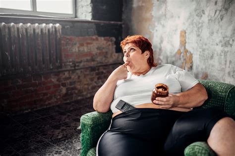 mujer con sobrepeso se sienta en una silla y come dulces estilo de vida poco saludable