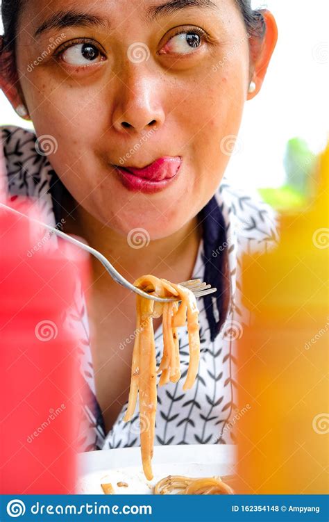 Facial Expression Of An Asian Adult Woman Who Really Enjoy Eating Delicious And Tasty Pasta In A