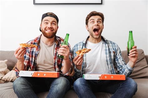 Premium Photo Two Agitated Emotional Men Eating Pizza And Drinking Beer With While Supporting